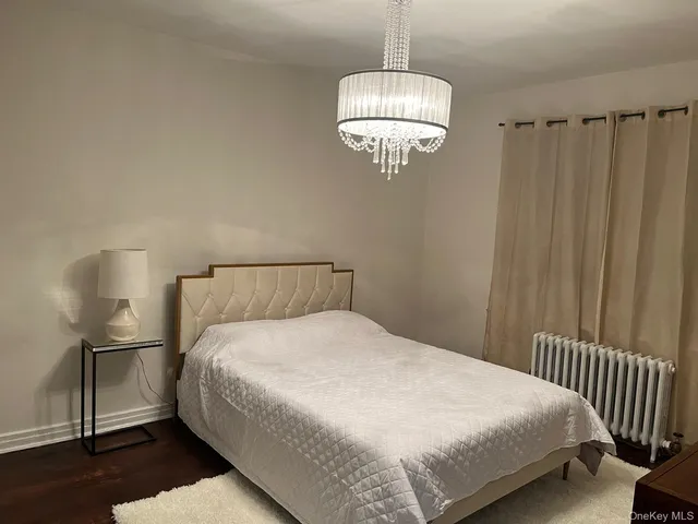 a bedroom with a bed and chandelier