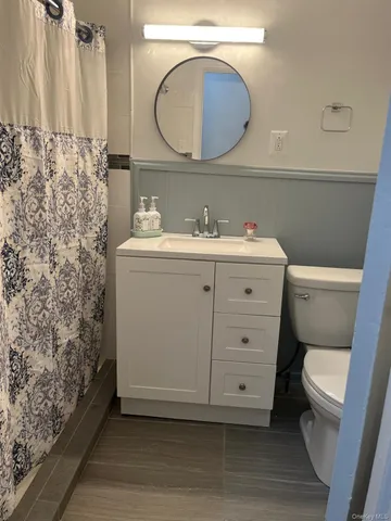 a bathroom with a sink a toilet and a mirror