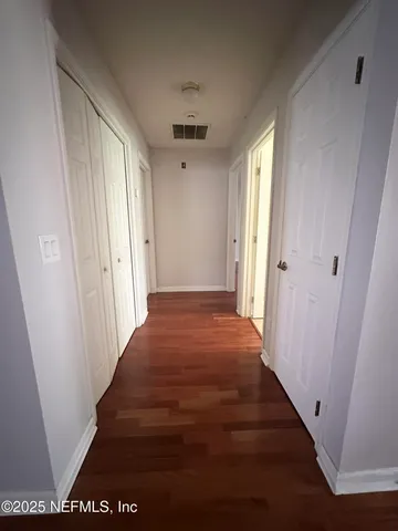 a view of a hallway with wooden floor and staircase