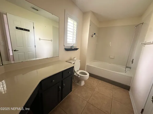 a bathroom with a granite countertop sink toilet a large mirror a bathtub and shower