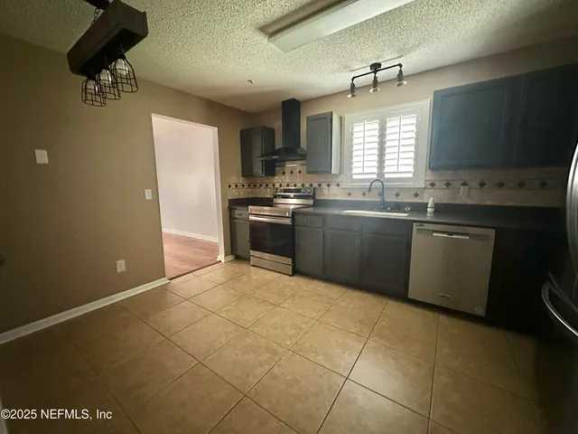 a large kitchen with granite countertop a sink and cabinets