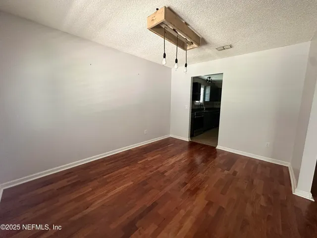 a view of a room with wooden floor and white walls