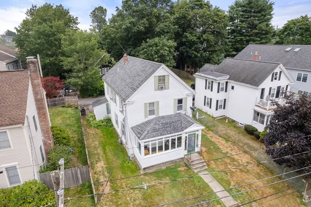 an aerial view of residential houses with yard and trees