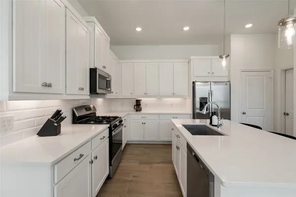 a kitchen with a sink a stove and cabinets