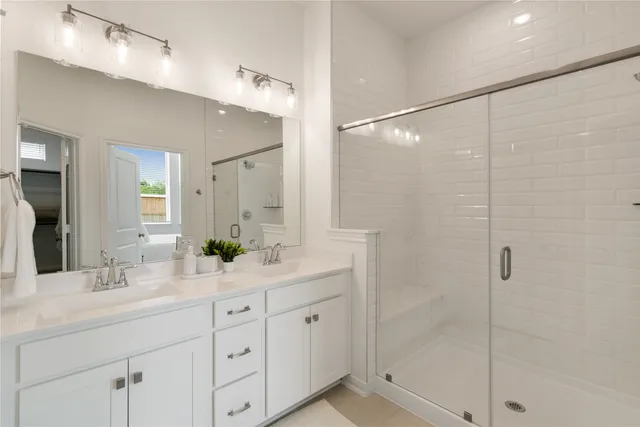 a bathroom with a shower sink and mirror