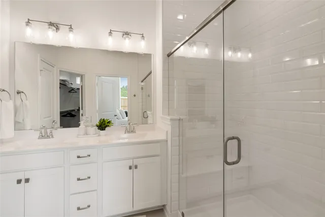 a bathroom with a sink double vanity and shower