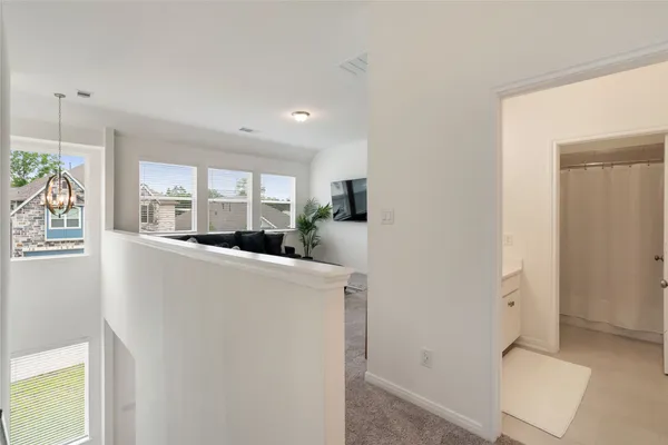 a living room with furniture a large window and storage space