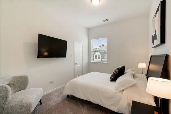 a bedroom with a bed and a flat screen tv