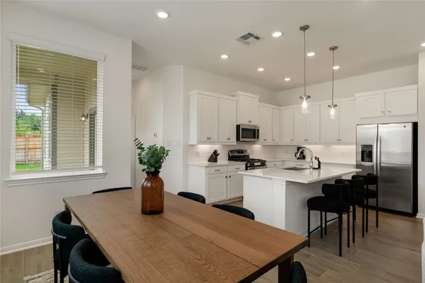 a kitchen with a table and chairs in it