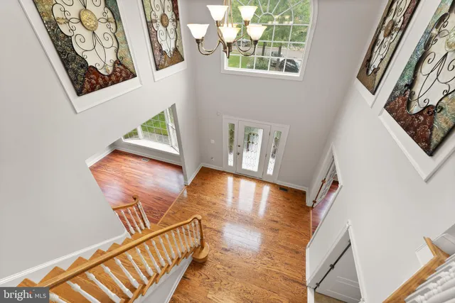 a view of an empty room with wooden floor and a bathroom