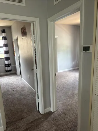 an empty room with windows and closet