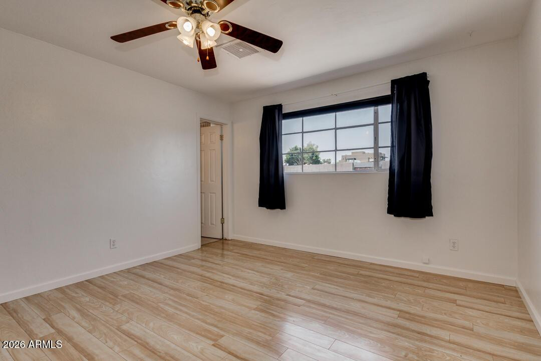 1308 West 6th Street Tempe, AZ 85281 - Photo 14 of 27 a view of empty room with wooden floor and fan