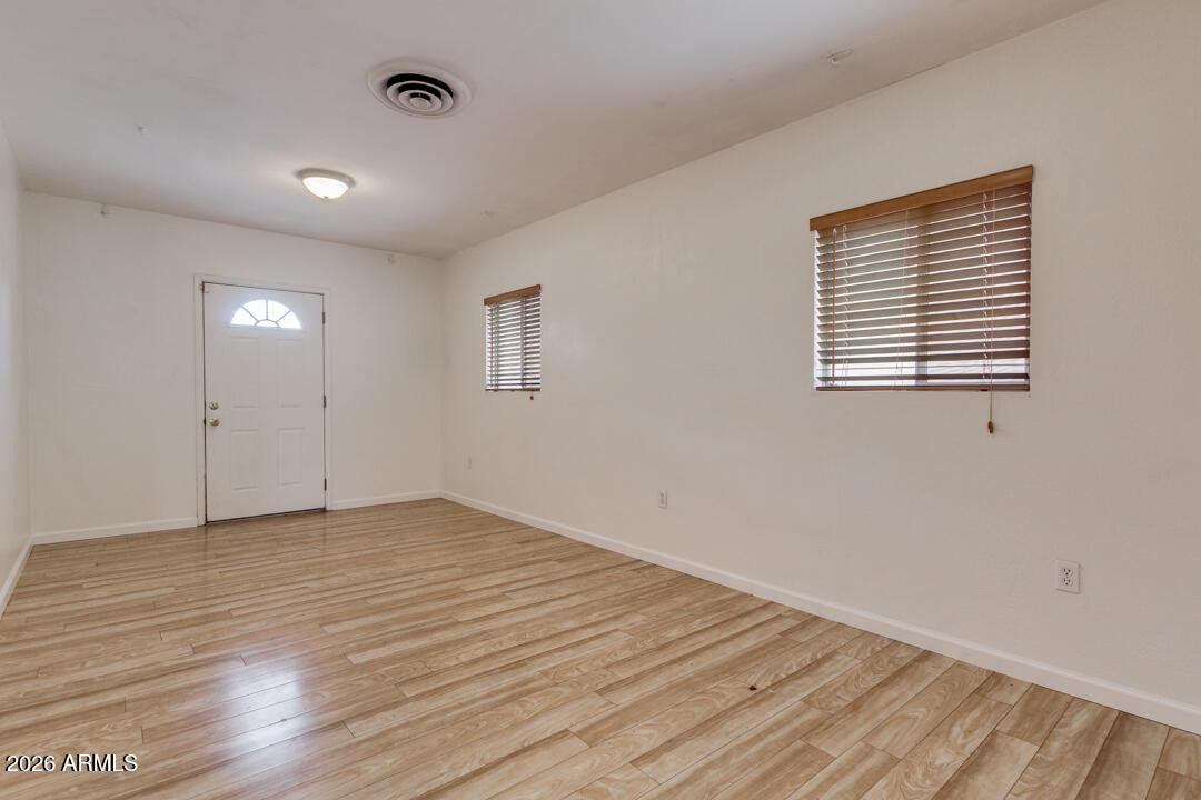 1308 West 6th Street Tempe, AZ 85281 - Photo 9 of 27 a view of an empty room with wooden floor and a window