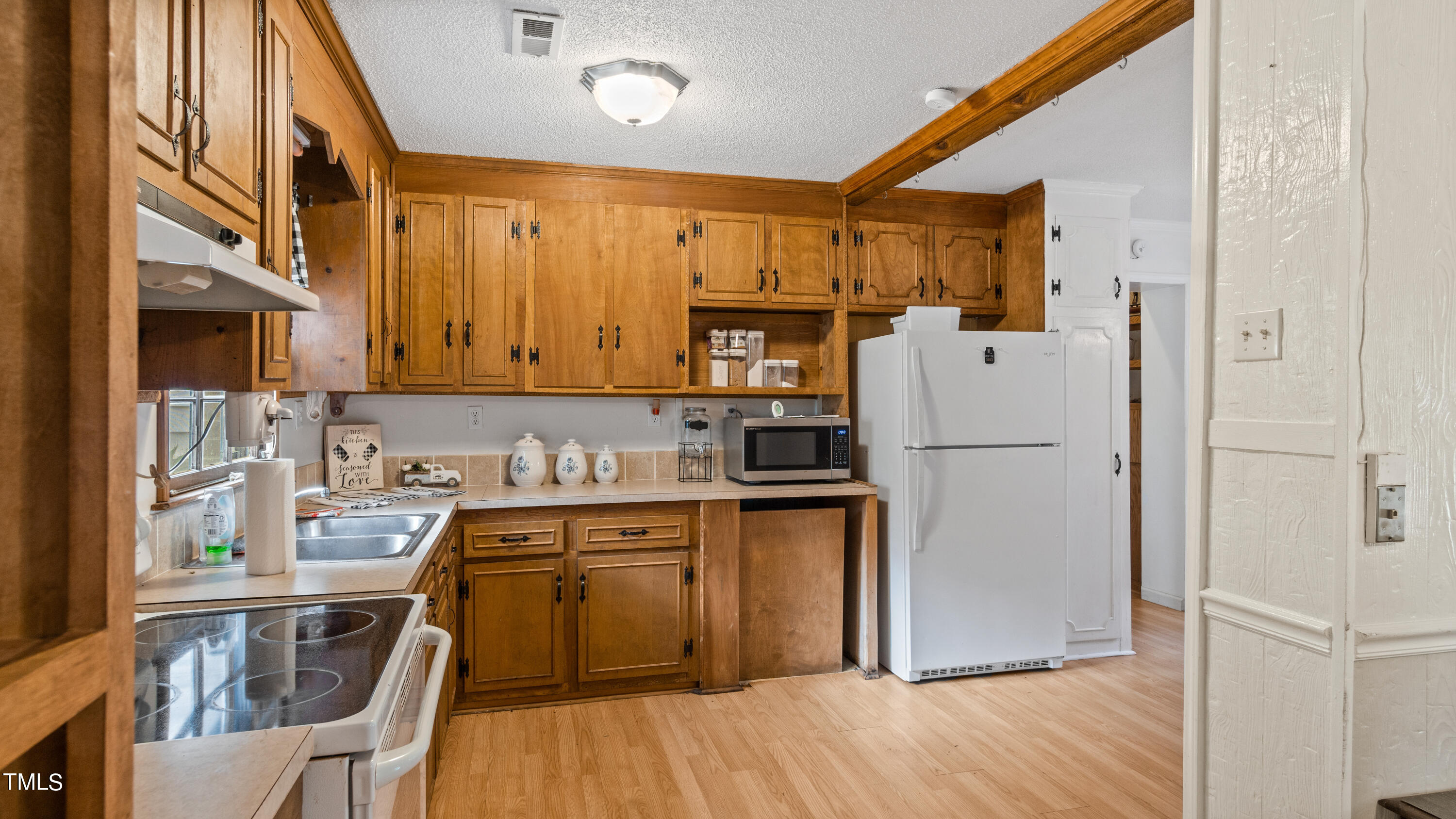 125 Walter Street Manson, NC 27553 - Photo 7 of 39 a kitchen with a sink a refrigerator and wooden cabinets