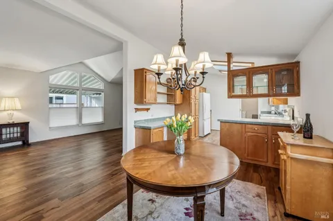a dining room with furniture a chandelier and wooden floor