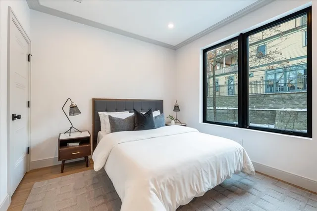 a bedroom with a bed and a large window