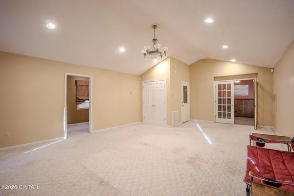 an empty room with windows and cabinet
