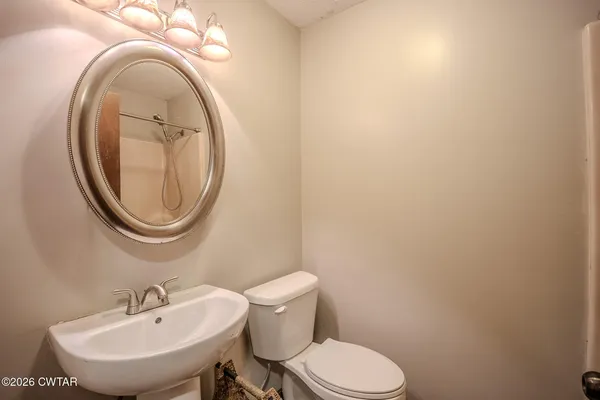 a bathroom with a toilet a sink and a mirror