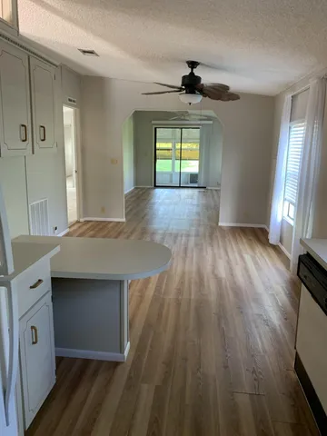 a kitchen with stainless steel appliances a dining table chairs stove refrigerator and cabinets