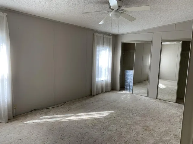 a bathroom with a granite countertop sink toilet a mirror a vanity and shower
