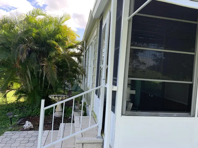 a view of a room with wooden floor a ceiling fan and windows