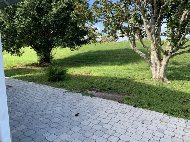 a front view of a house with a yard and potted plants