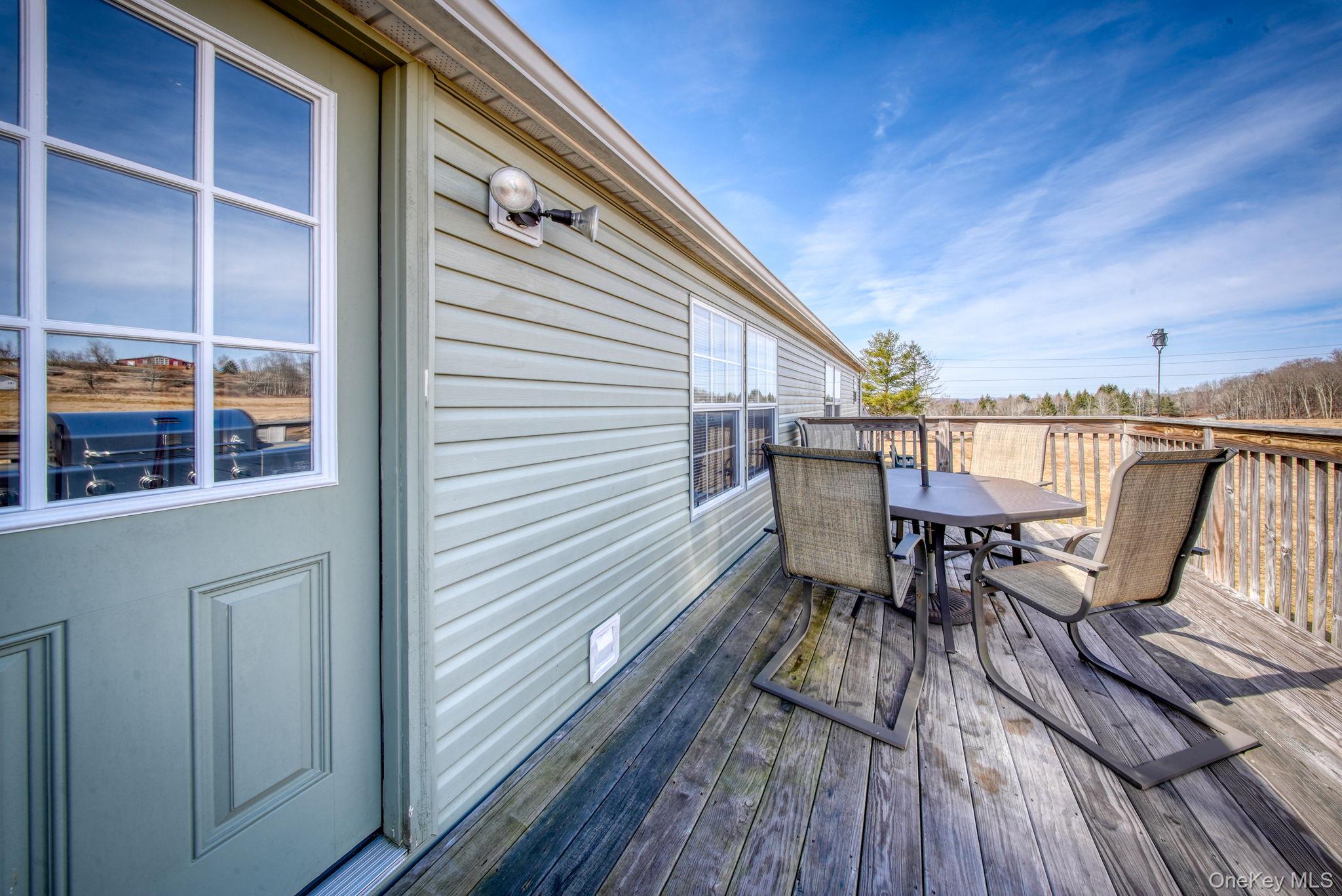 221 Gabel Road Callicoon, NY 12723 - Photo 38 of 44 a view of a roof deck with table and chairs wooden floor and fence