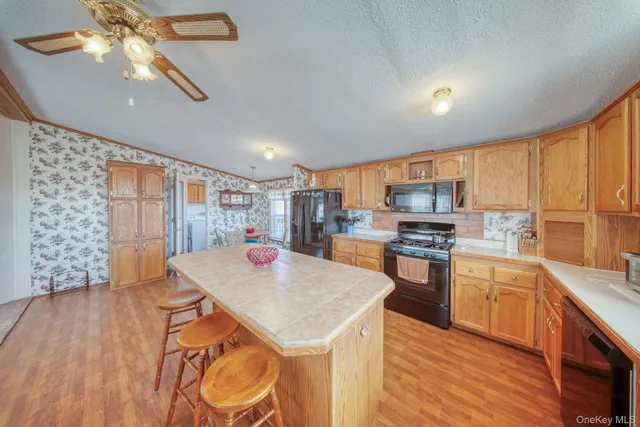 a kitchen with stainless steel appliances granite countertop a stove a sink dishwasher and a microwave oven with cabinets