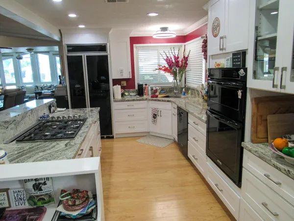 a kitchen with stainless steel appliances granite countertop a refrigerator and a stove top oven