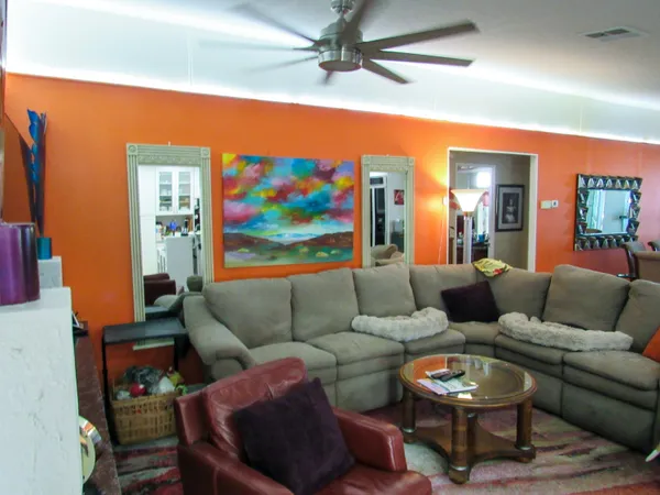 a living room with furniture and a painting on the wall