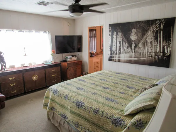 a bedroom with a bed and a flat screen tv