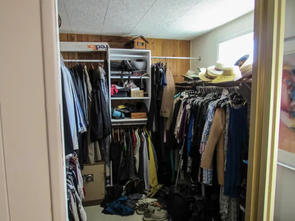 a view of walk in closet with clothes