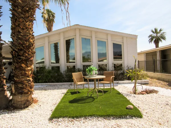 a view of a house with backyard and sitting area