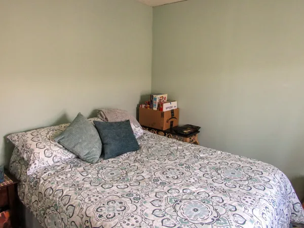 a bedroom with a bed and a wooden floor