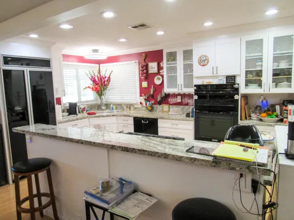 a kitchen with stainless steel appliances kitchen island granite countertop a sink and a refrigerator
