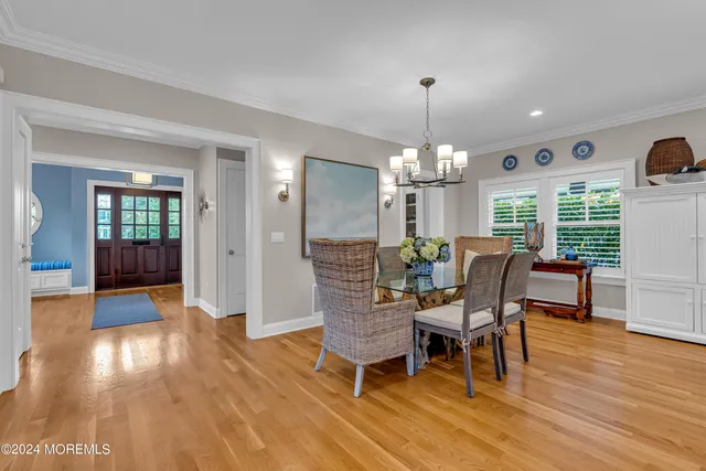a dining room with furniture a chandelier and wooden floor