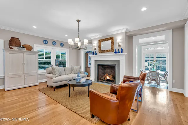 a living room with furniture a chandelier and a fireplace