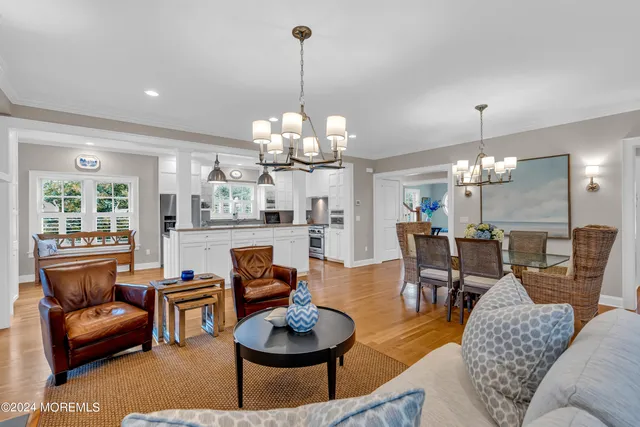 a living room with furniture a chandelier and a dining room