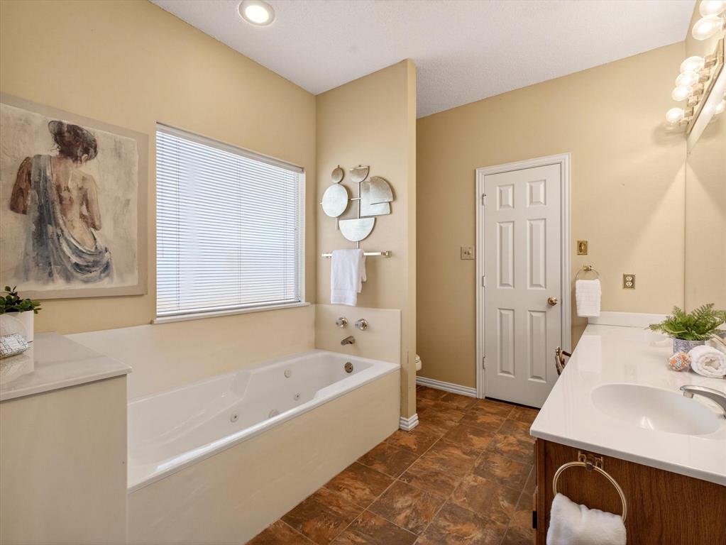 4345 Timberglen Road Dallas, TX 75287 - Photo 17 of 26 a bathroom with a bathtub and a sink