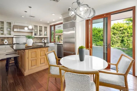 a kitchen with stainless steel appliances granite countertop a dining table chairs and granite counter tops