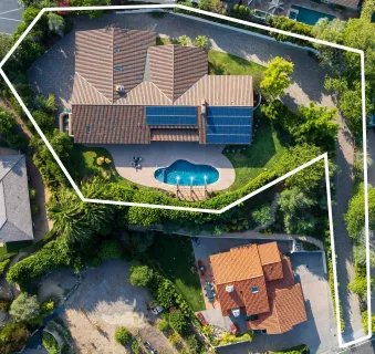 an aerial view of a house with a garden and a sitting area