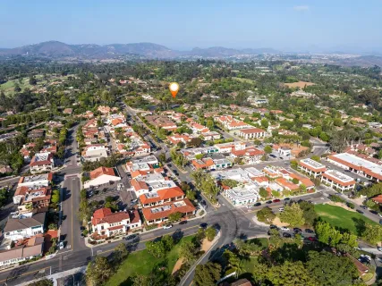 an aerial view of residential houses with outdoor space and trees