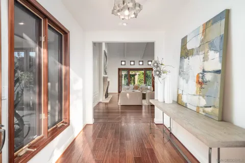 a view of a hallway with wooden floor windows and a livingroom