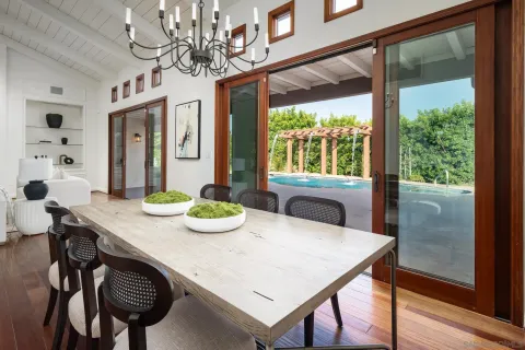 a view of a dining room with furniture a chandelier and wooden floor