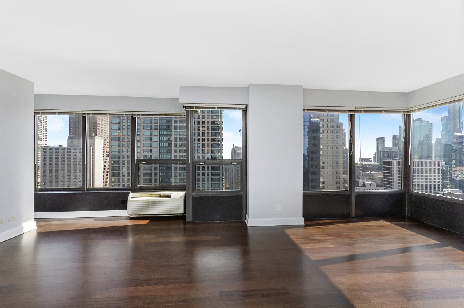 30 East Huron Street, Unit 3602 Chicago, IL 60611 - Photo 4 of 15 a view of empty room with wooden floor and floor to ceiling window