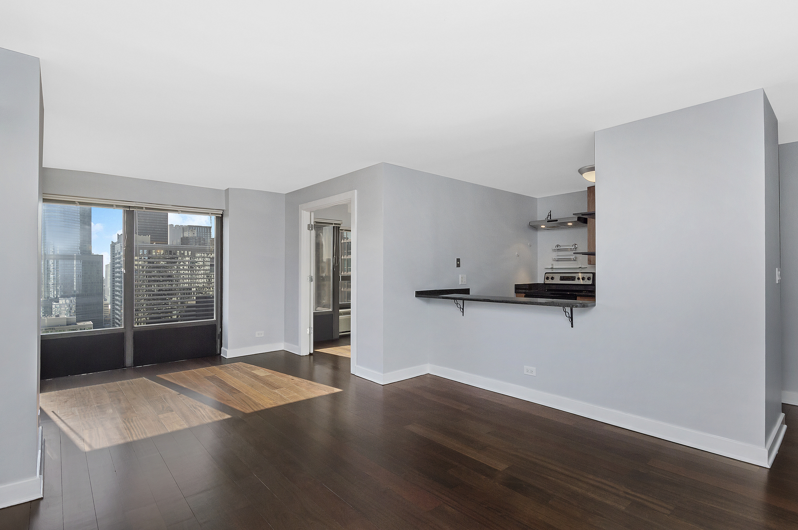 30 East Huron Street, Unit 3602 Chicago, IL 60611 - Photo 7 of 15 a view of a kitchen with wooden floor a sink and a window