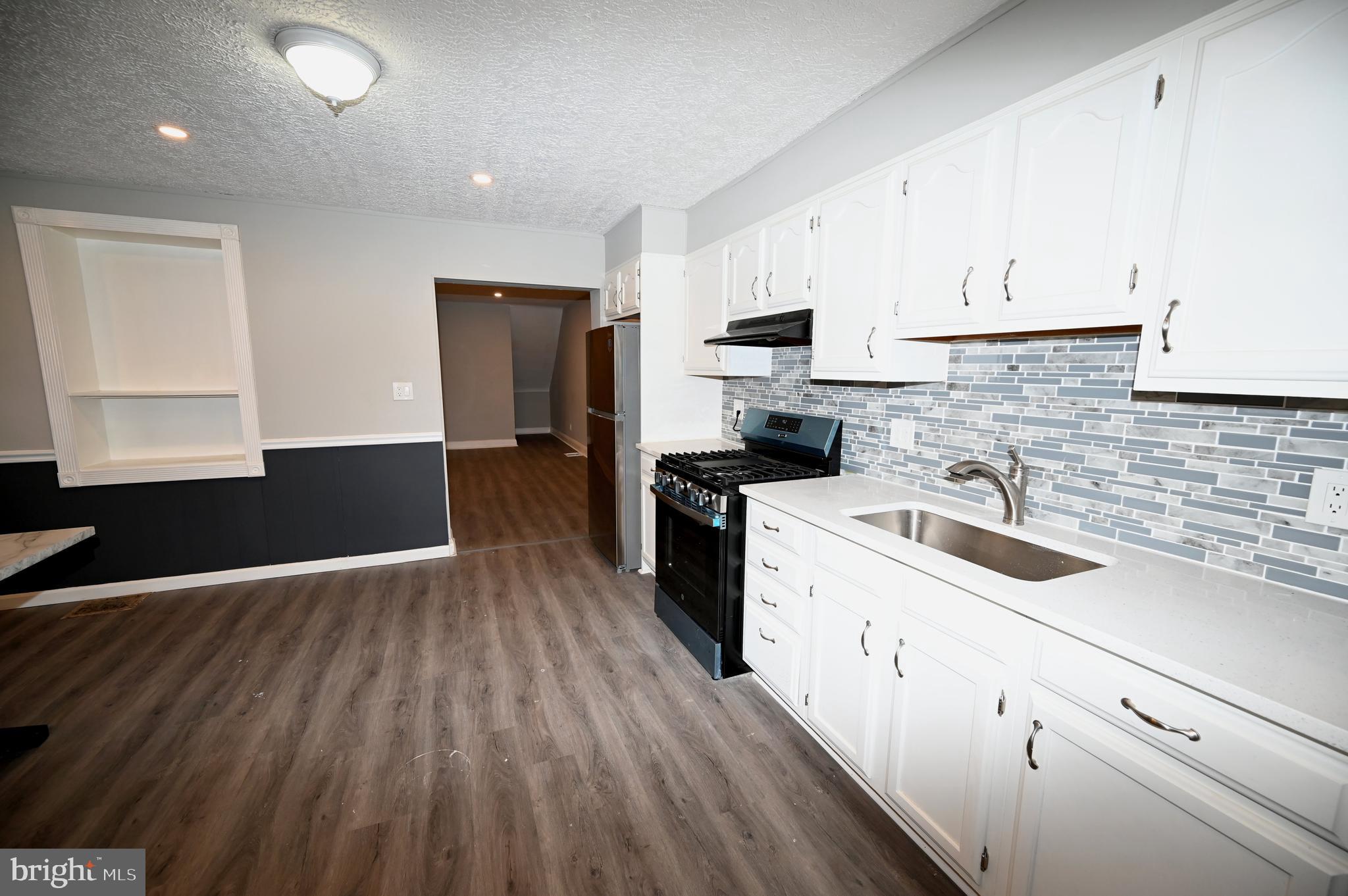 2952 Sollers Point Road, Unit B Dundalk, MD 21222 - Photo 30 of 37 a kitchen with wooden cabinets and white appliances