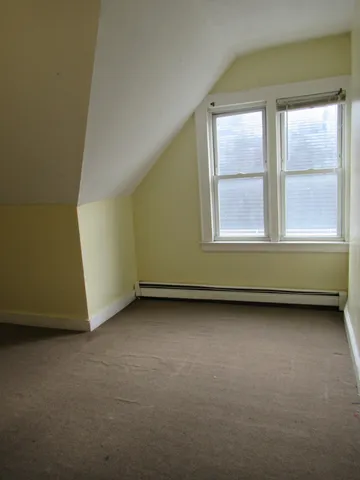 an empty room with a fireplace and windows