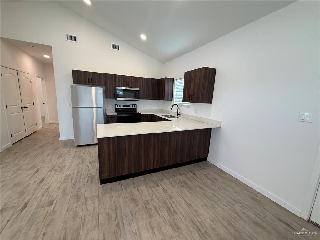 2701 Brownjay Road, Unit #3 Weslaco, TX 78596 - Photo 4 of 18 a kitchen with stainless steel appliances a refrigerator and a stove top oven
