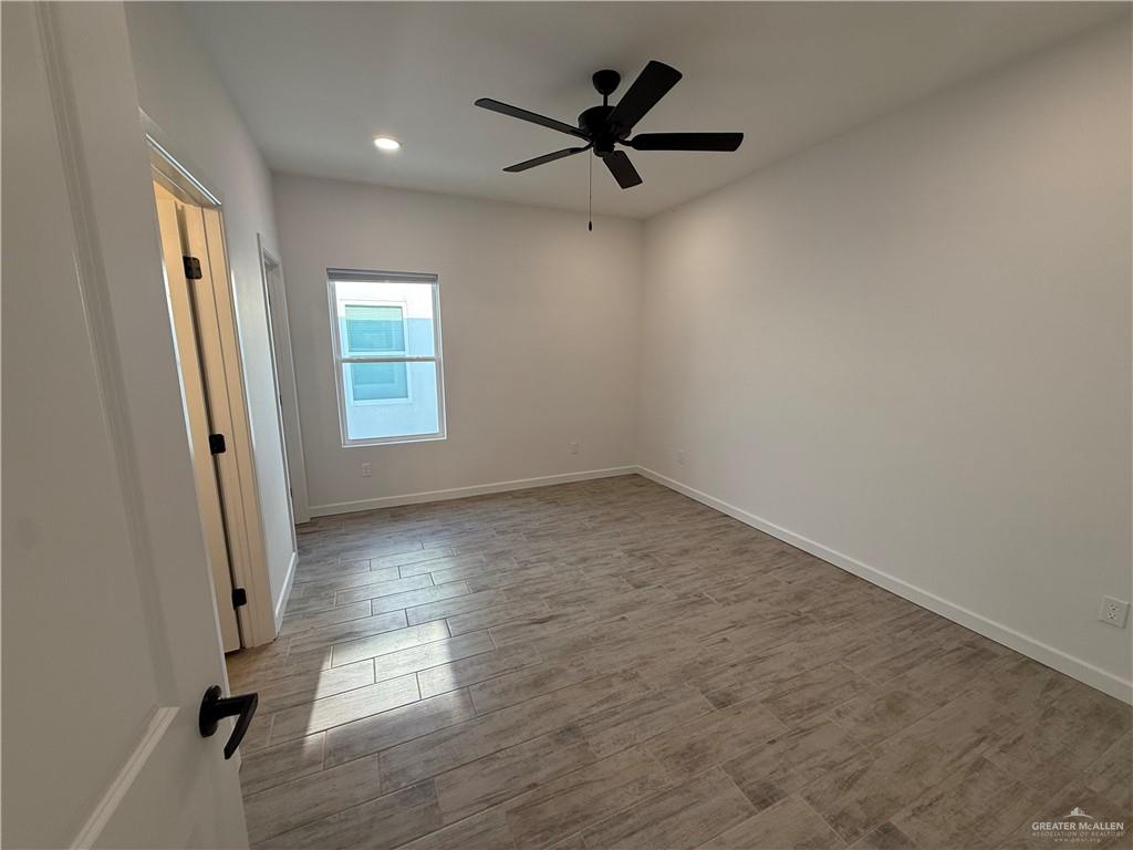 2701 Brownjay Road, Unit #3 Weslaco, TX 78596 - Photo 9 of 18 wooden floor in an empty room with a window